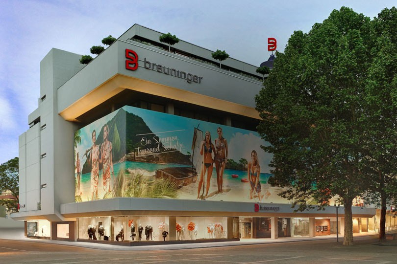 Breuninger department store building exterior with large summer-themed advertisement.